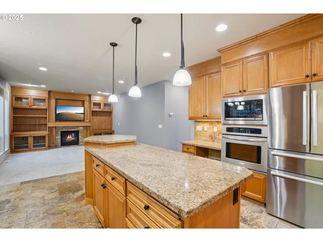 a kitchen with stainless steel appliances granite countertop a sink refrigerator and microwave
