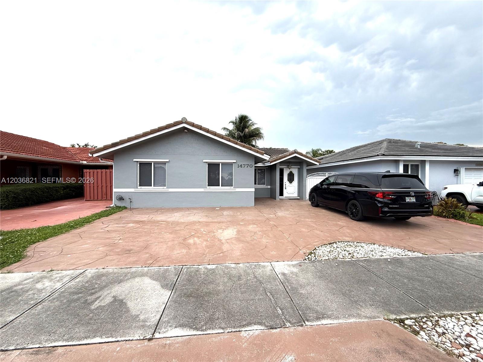 14770 Southwest 60th Street Miami, FL 33193 - Photo 1 of 16 a car parked in front of a house