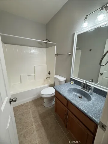 a bathroom with a granite countertop sink mirror vanity and toilet