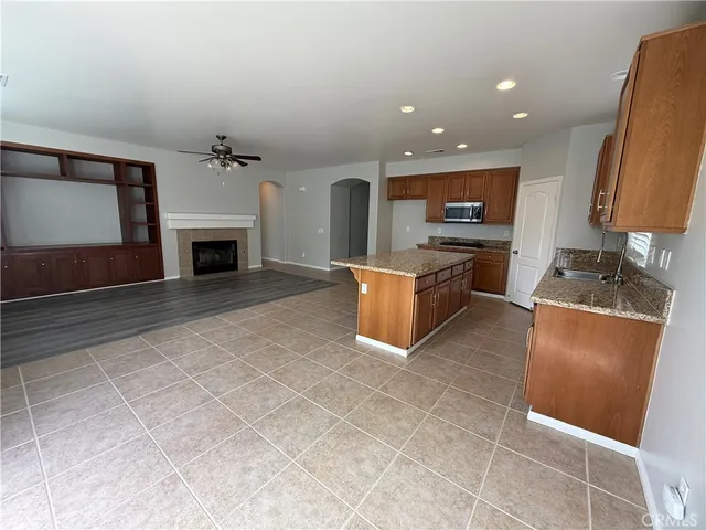 a living room with stainless steel appliances furniture a fireplace and a counter top