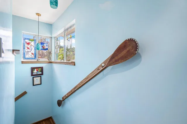 a view of a hallway with paintings on the wall and a window