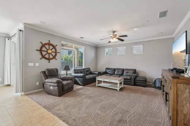 a living room with furniture ceiling fan and a window