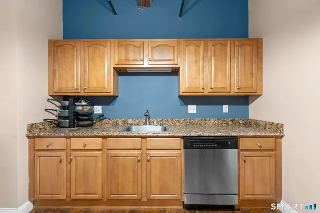 a kitchen with granite countertop cabinets stainless steel appliances and a counter space