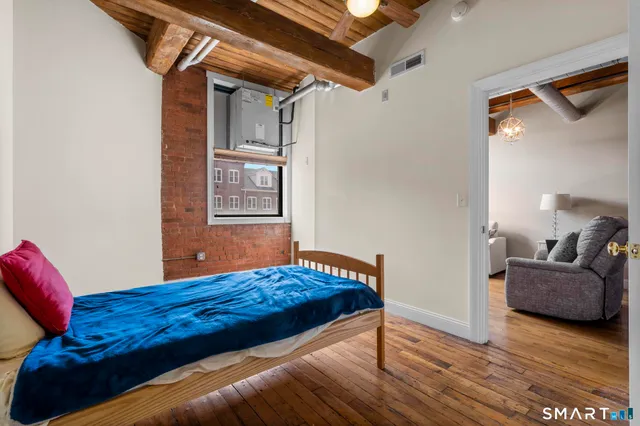 a bedroom with a bed and wooden floor
