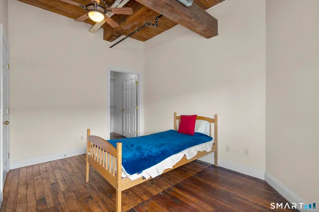 a room with a bed and wooden floor