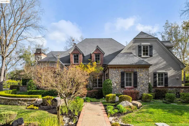 a front view of a house with garden and sitting area