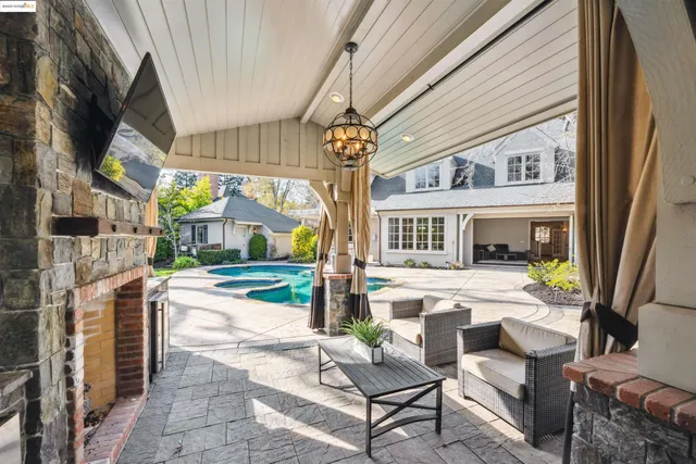 a view of a white house with a yard plants and large tree
