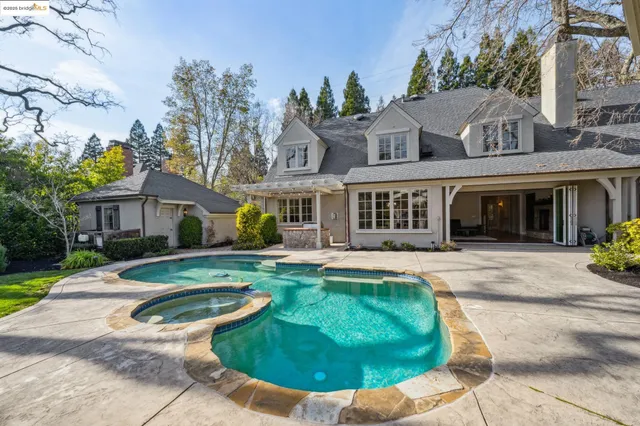 a view of a patio with table and chairs potted plants and a large tree