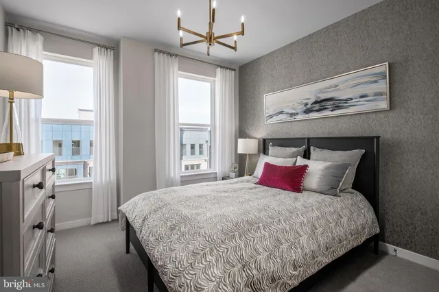 a bedroom with a large bed and a chandelier