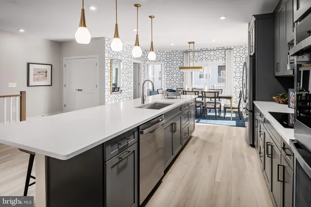 a large kitchen with kitchen island a sink a counter space appliances and cabinets