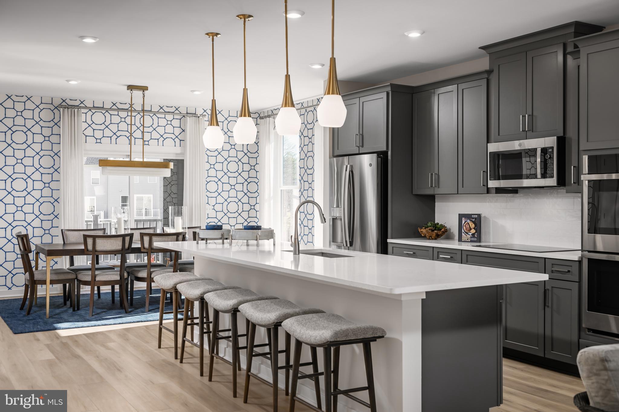 2167 Glacier Road Herndon, VA 20170 - Photo 7 of 32 a kitchen with stainless steel appliances a dining table chairs refrigerator and microwave