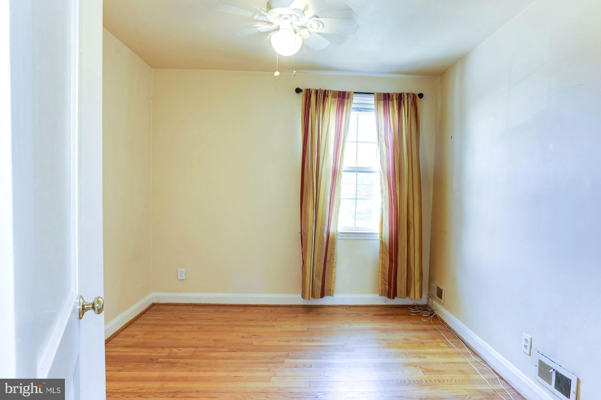 3602 Delverne Road Baltimore, MD 21218 - Photo 14 of 28 an empty room with wooden floor and windows