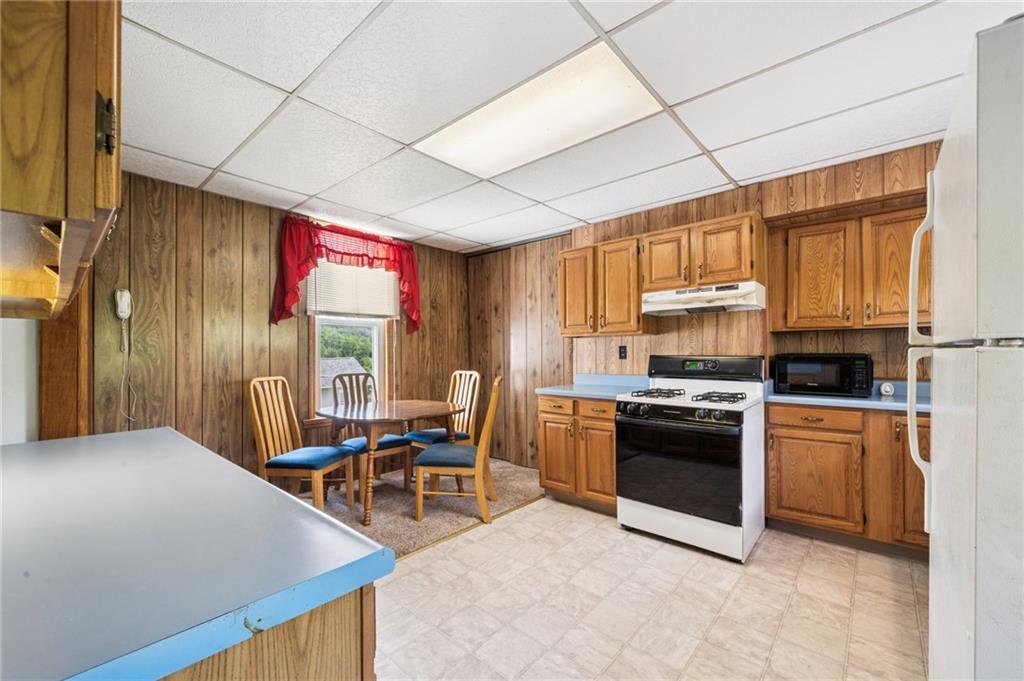 600 Scott Street Penn, PA 15675 - Photo 11 of 33 a kitchen with stainless steel appliances granite countertop a stove a refrigerator a sink dishwasher a dining table and chairs with wooden floor