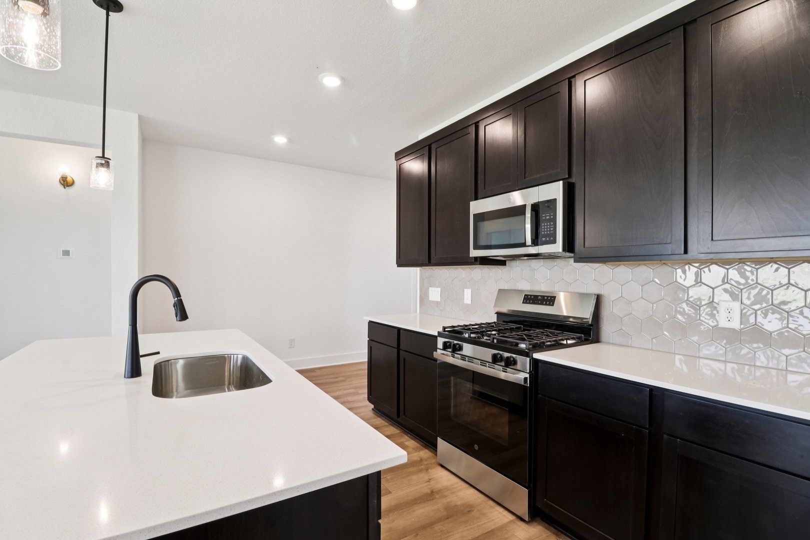 14470 Trumpet Lane Splendora, TX 77372 - Photo 7 of 27 a kitchen with granite countertop a sink a stove and kitchen island with wooden floor