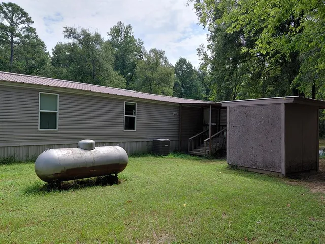 a view of a backyard with plants and a tub