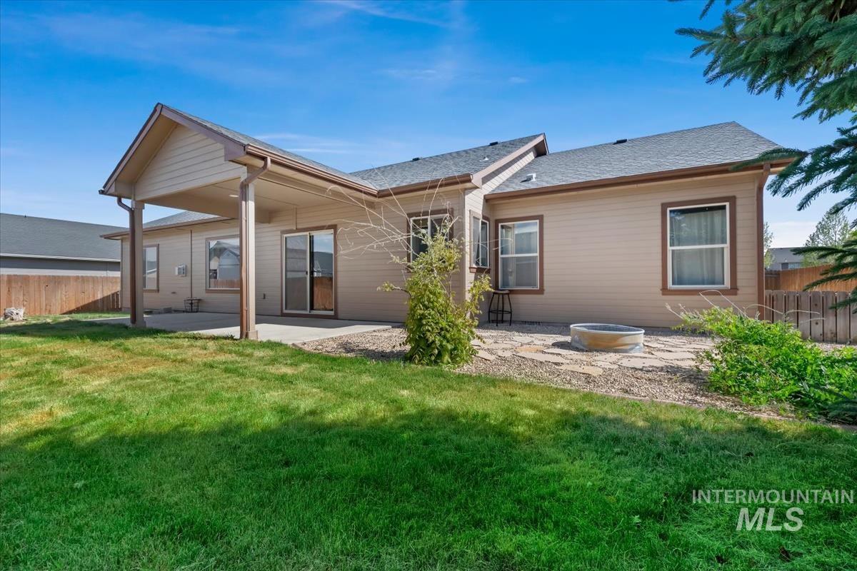 640 Southwest Miner Street Mountain Home, ID 83647 - Photo 17 of 35 Expansive backyard featuring a covered patio, concrete slab, and sliding glass door access