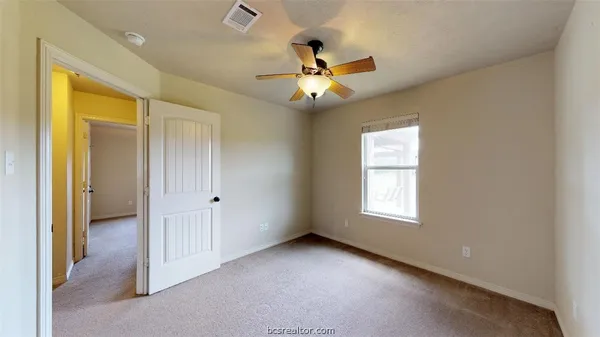a view of an empty room and window ceiling fan
