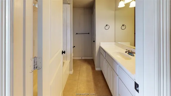 a bathroom with a granite countertop tub sink and mirror