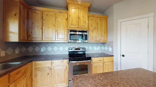 a kitchen with stainless steel appliances granite countertop a stove a sink and a microwave