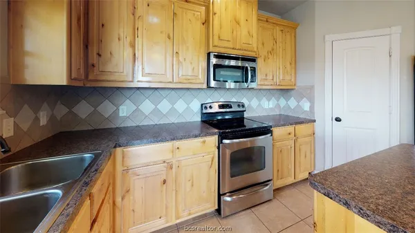 a kitchen with stainless steel appliances granite countertop a sink and a stove