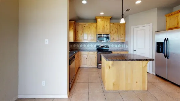 a kitchen with stainless steel appliances granite countertop a sink and a refrigerator
