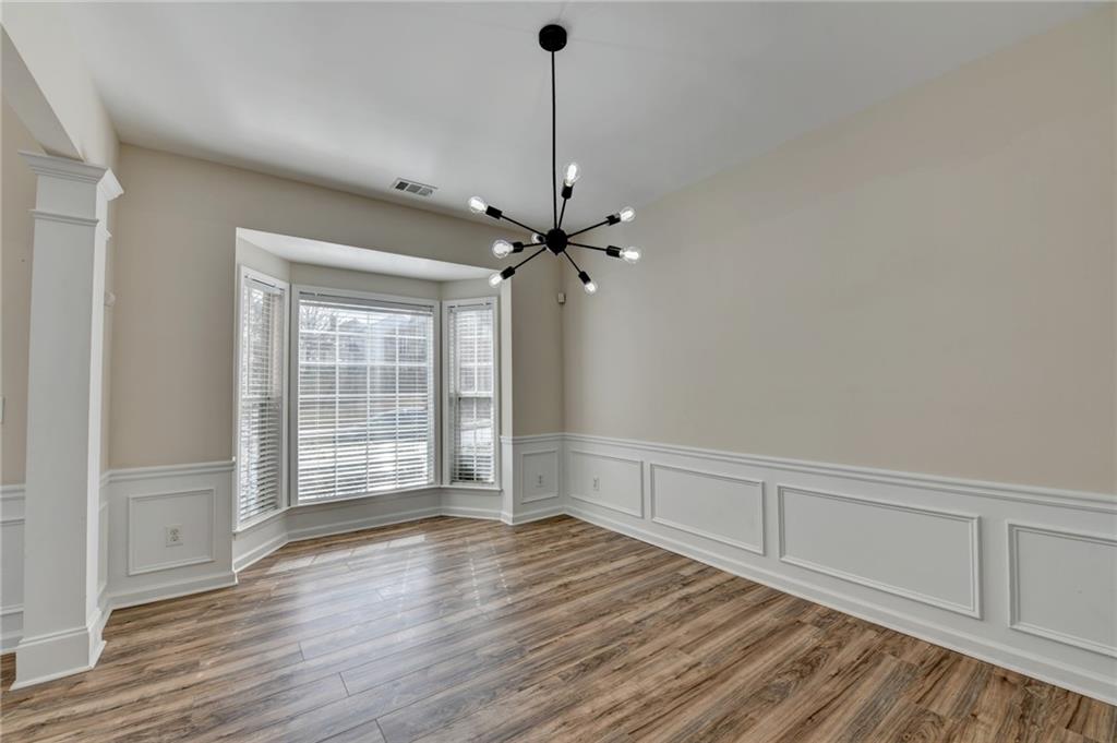 100 Hawnley Trc Northwest Suwanee, GA 30024 - Photo 7 of 58 wooden floor in an empty room with a window