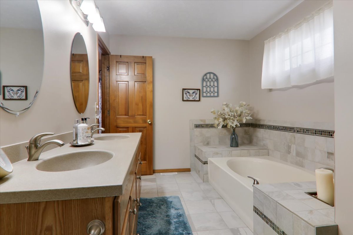 8 Minks Court Bloomington, IL 61704 - Photo 20 of 40 a bathroom with a tub sink and mirror