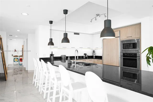 a kitchen with stainless steel appliances a sink a window and cabinets