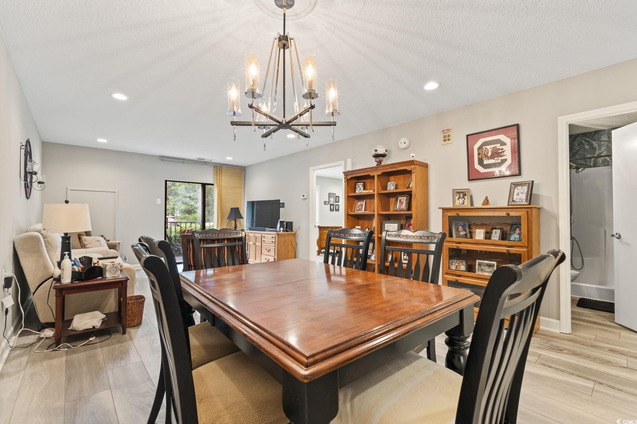 5001 Little River Road, Unit W102 Myrtle Beach, SC 29577 - Photo 2 of 38 Dining space with light wood-style floors, a chandelier, recessed lighting, and a textured ceiling