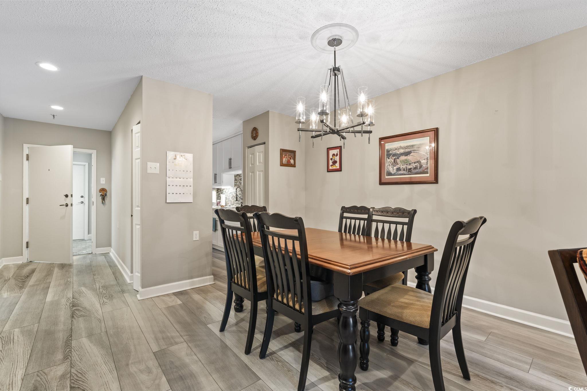5001 Little River Road, Unit W102 Myrtle Beach, SC 29577 - Photo 3 of 38 Dining room featuring a chandelier, light wood-style floors, a textured ceiling, and recessed lighting