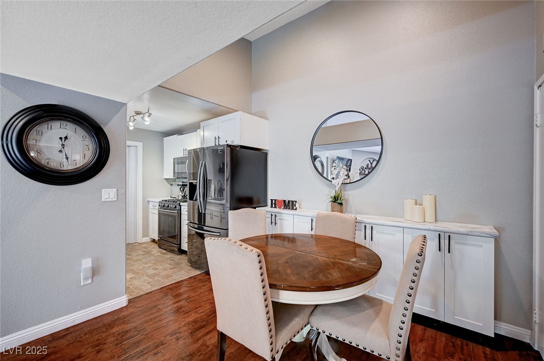 7885 West Flamingo Road, Unit 2023 Las Vegas, NV 89147 - Photo 12 of 34 Dining space featuring a textured ceiling, dark wood finished floors, and baseboards