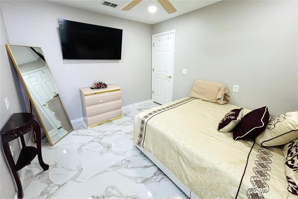 13451 Knotty Lane Hudson, FL 34669 - Photo 16 of 34 a bedroom with a bed and a flat screen tv