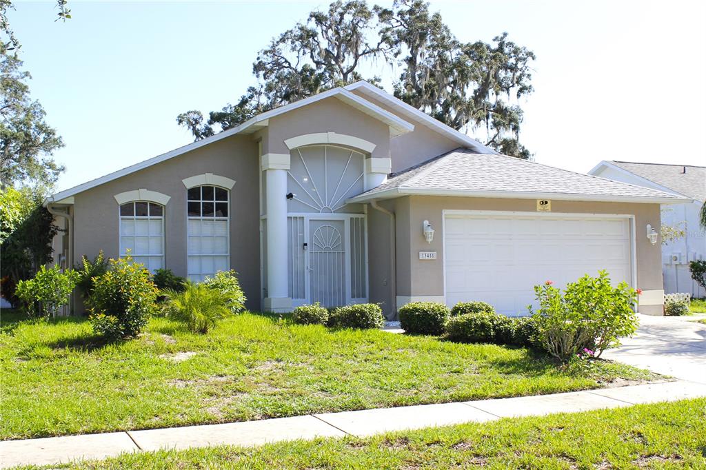 13451 Knotty Lane Hudson, FL 34669 - Photo 3 of 34 a front view of a house with garden