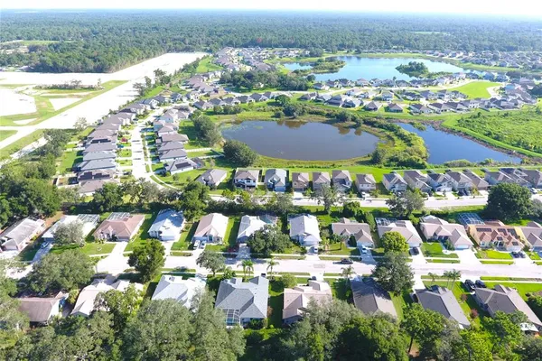 an aerial view of lake residential house with swimming pool and green space