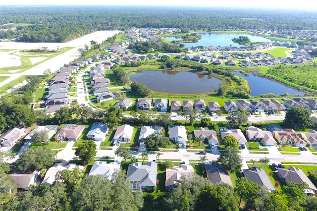 an aerial view of lake residential house with swimming pool and green space