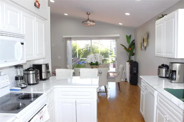 a kitchen with white cabinets and white appliances