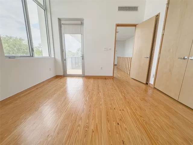an empty room with wooden floor and a window
