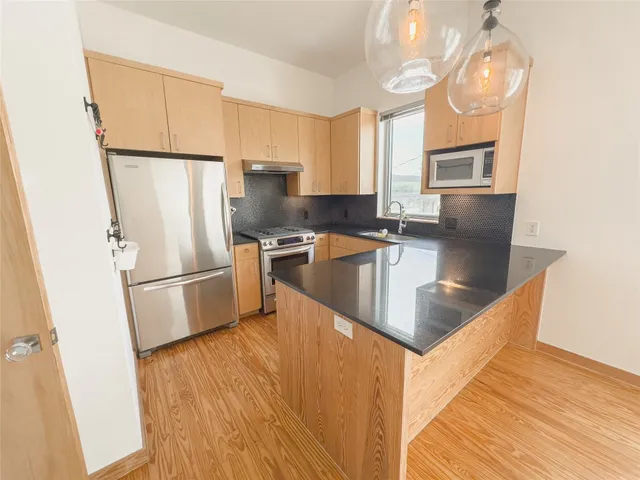 a kitchen with granite countertop a refrigerator stove and sink