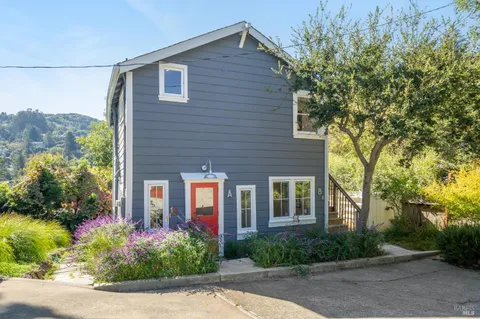 a front view of a house with a yard and large trees