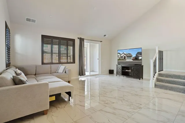 a bedroom with a bed couch and a larger window