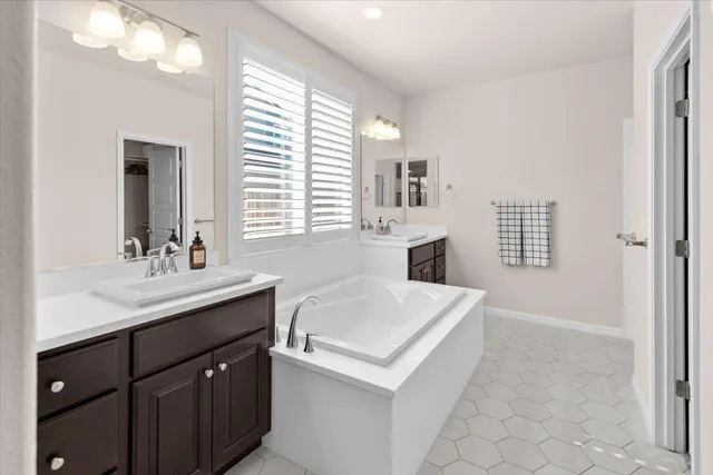 a en suite bathroom with a granite countertop sink and a mirror