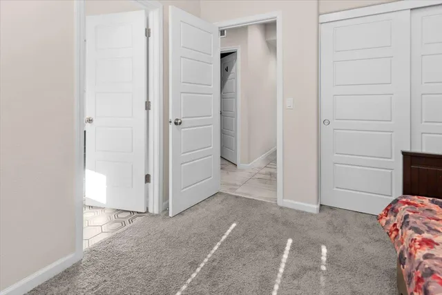 a view of a hallway with wooden floor and a bathroom