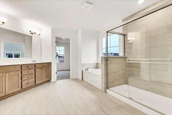a spacious bathroom with a granite countertop sink a toilet a mirror and shower