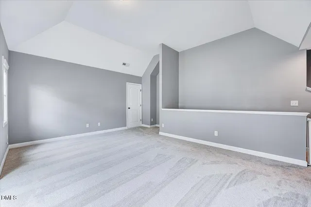 an empty room with windows and chandelier fan