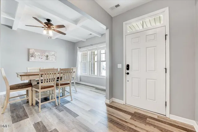 a dining room with wooden floor a ceiling fan and a rug