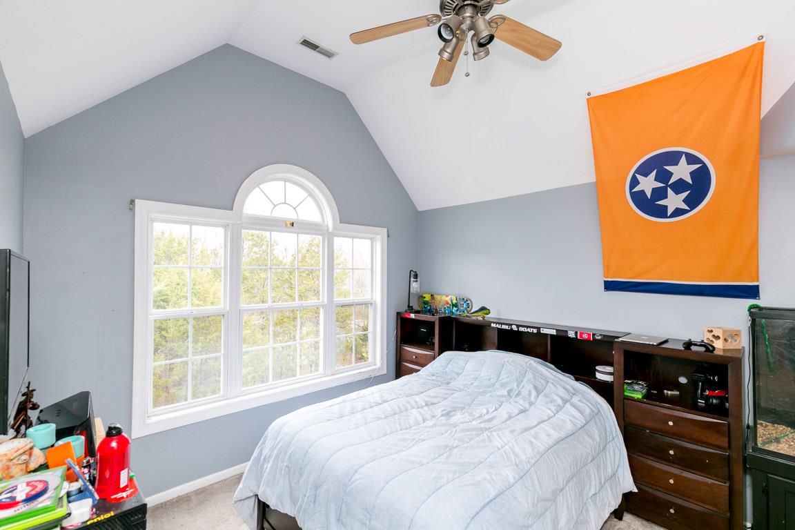 1160 Waller Road Brentwood, TN 37027 - Photo 21 of 28 a bedroom with a bed and a chandelier