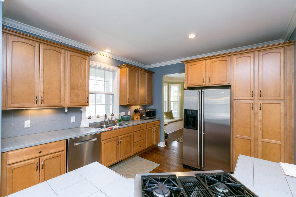 1160 Waller Road Brentwood, TN 37027 - Photo 6 of 28 a kitchen with stainless steel appliances granite countertop a refrigerator a sink dishwasher a stove and white countertops with wooden floor
