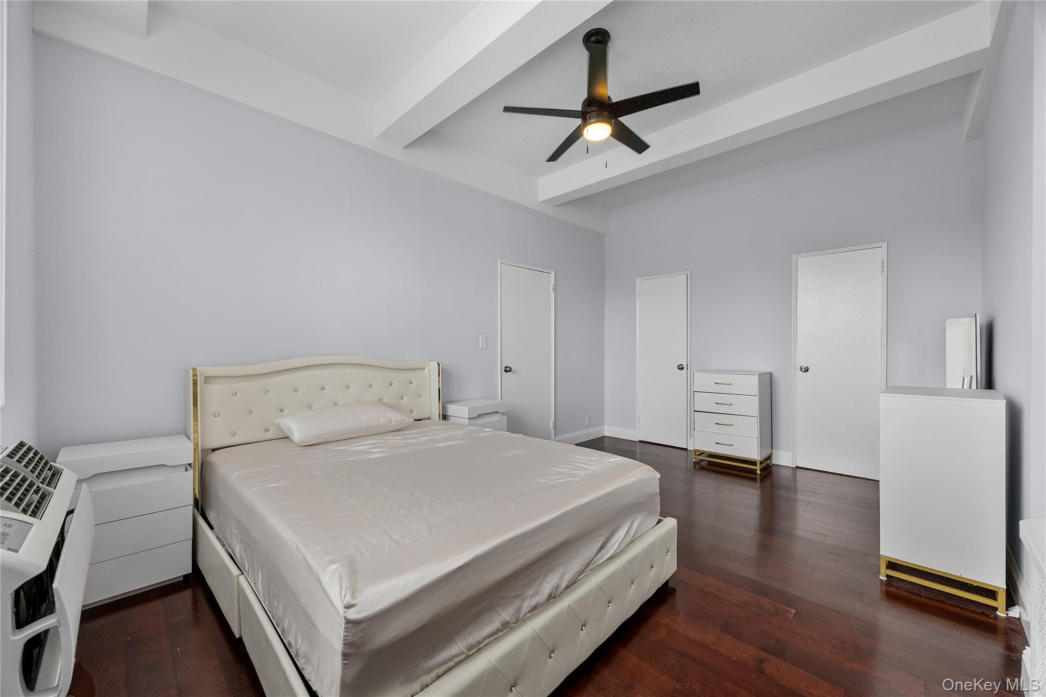 355 Bronx River Road, Unit 1I Yonkers, NY 10704 - Photo 12 of 22 Bedroom with beamed ceiling, wood finished floors, a wall unit AC, heating unit, and a ceiling fan