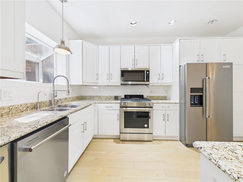 138 North Woodland Road Pittsburgh, PA 15232 - Photo 11 of 50 a kitchen with kitchen island granite countertop a sink stainless steel appliances and white cabinets
