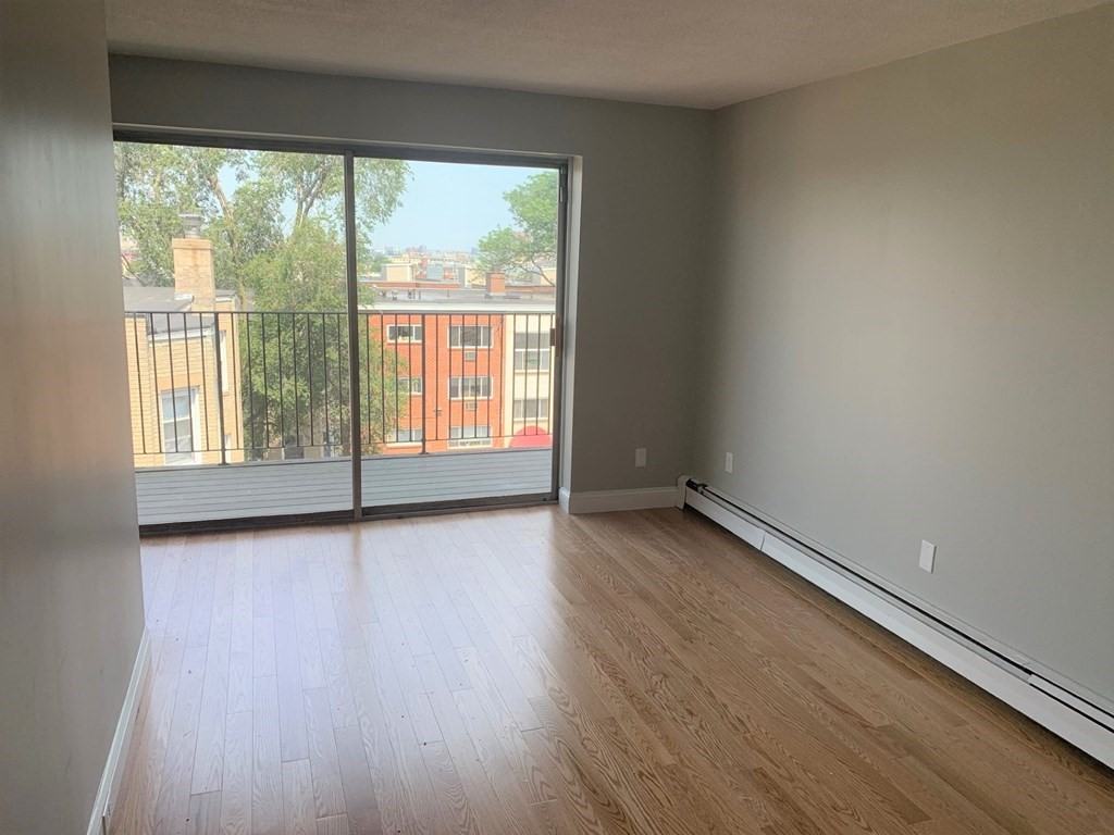 36 Bellvista Road, Unit 47 Boston, MA 02135 - Photo 5 of 12 an empty room with wooden floor and windows